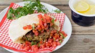 Pitabroodje gevuld met pestoburger en tomaten