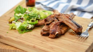 Varkensribbetjes met Romeinse sla, gebakken patatjes en een vinaigrette van roquefort 