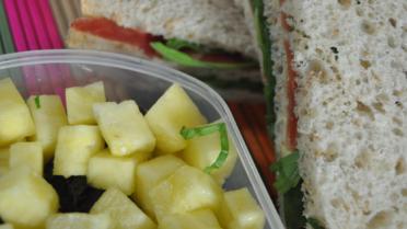 Stapelsandwich met parmaham, raketsla en honing met ananas salade