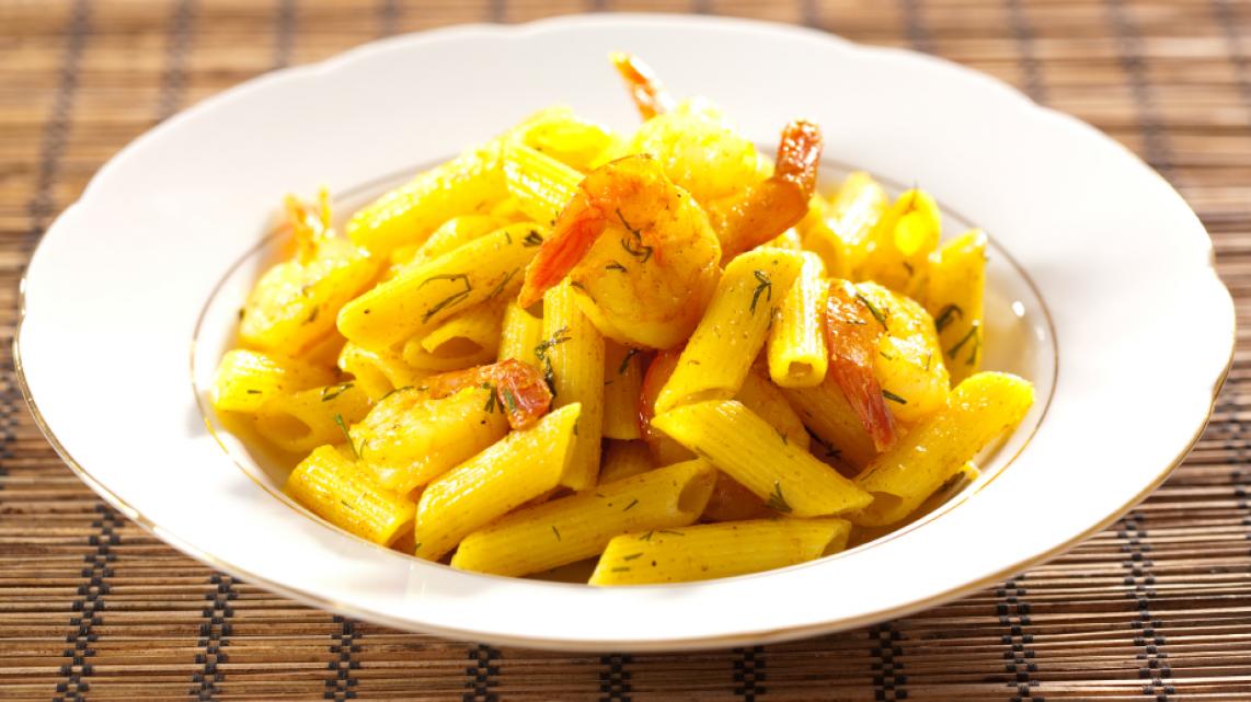 Penne met scampi en zoete currydressing